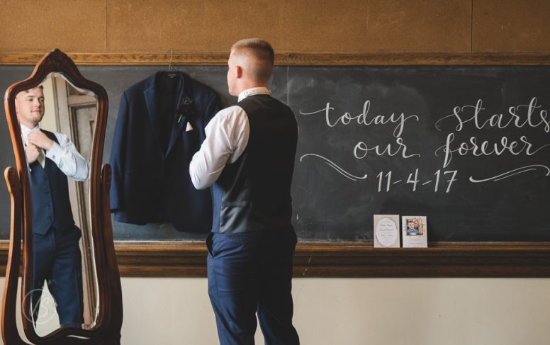 groom getting ready in mirror