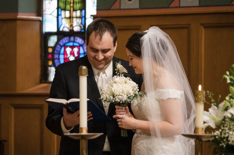Bride and groom looking at hymnal at wedding ceremony