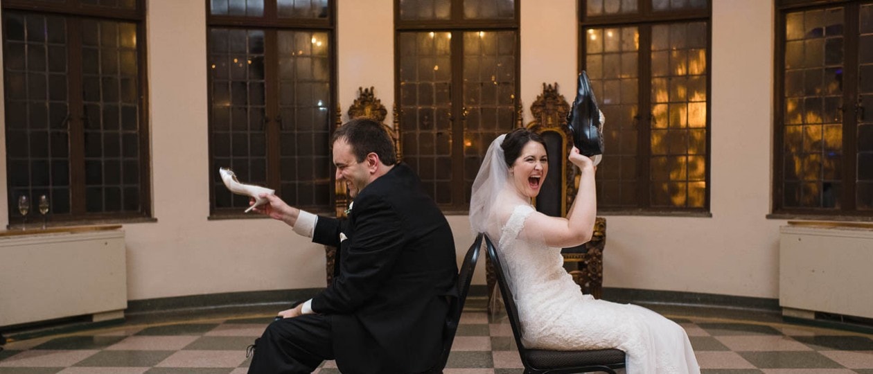 Couple playing shoe game at their wedding reception