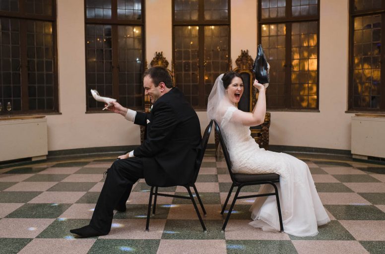 Couple playing shoe game at their wedding reception