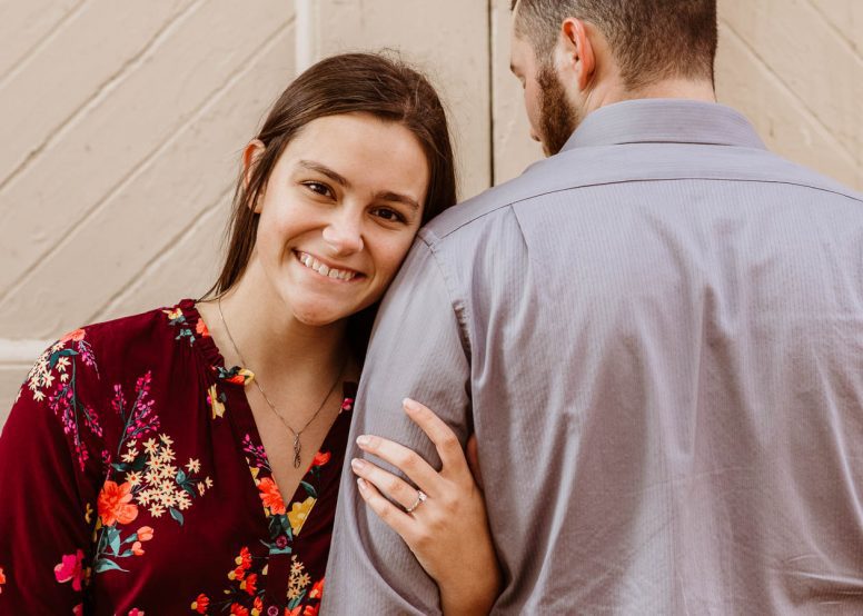 Young women smiling with arm around fiancé