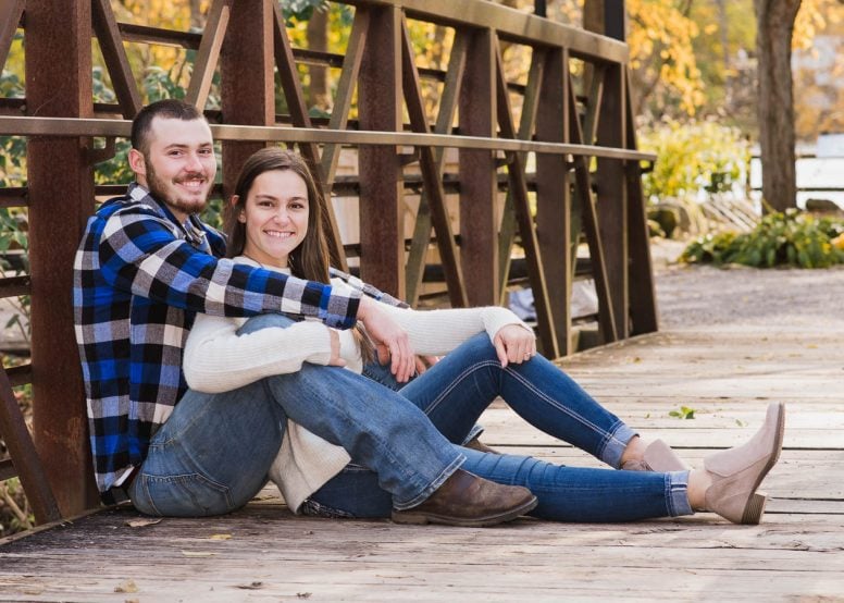 Couple sitting together on a bridge