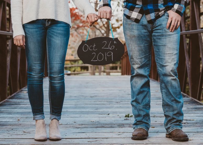 Couple holding sign of their wedding date